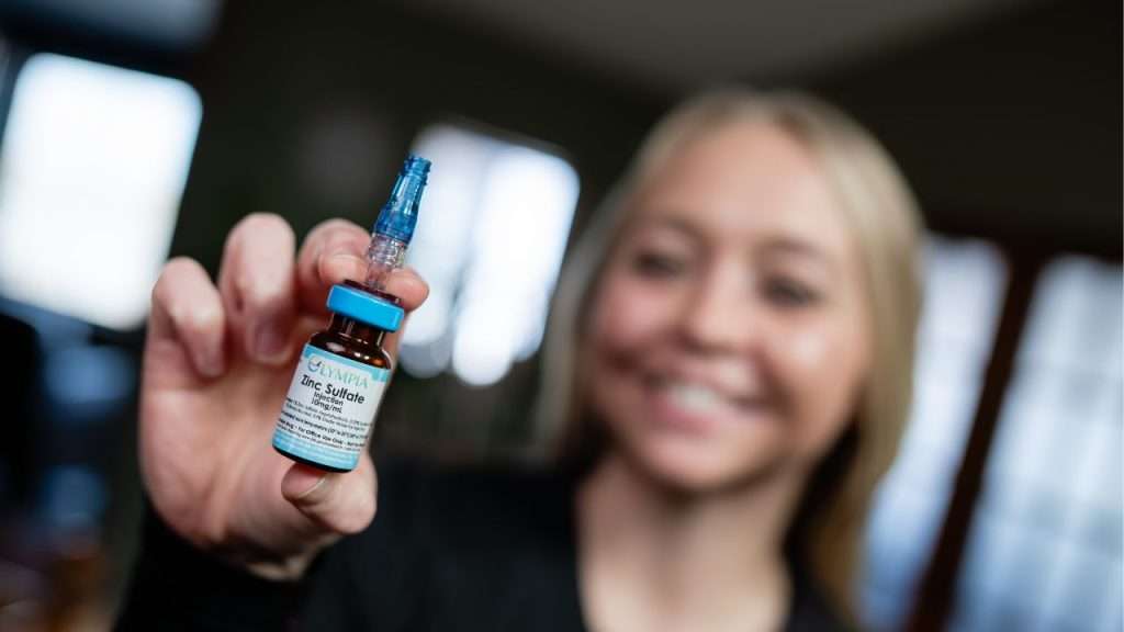 woman smiling holding a nutrient that is put within IVs